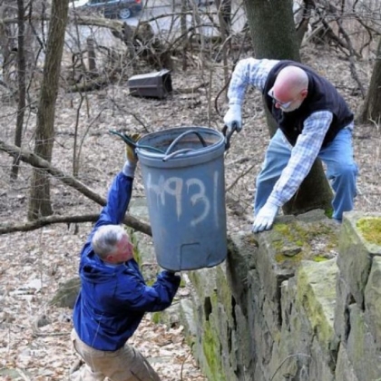 Retired volunteer John Cokley passes collected trash to Joseph Divack of Allegheny CleanWays as RSVP volunteers pick up litter above Steuben Street in the West End section of Pittsburgh.