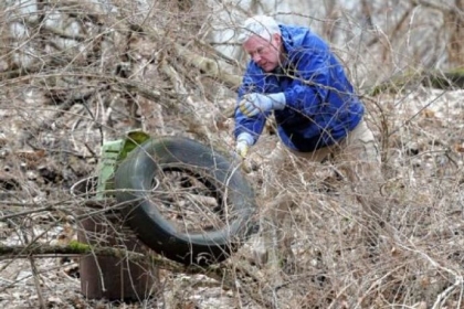 Retired volunteer John Cokley picks up litter on a hillside above Steuben Street in Pittsburgh?s West End.