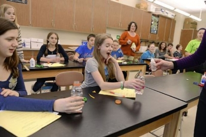 Seventh-grade science teacher Angela Lamers, far right, tests students Gwen Koladish, 12, center, and Lilli Horvat, 13, to see if their plastic bottles have become "infected" Wednesday at Hampton Middle School. Students participated in a simulated outbreak in which they were exposed to various contagions. Students then researched their "infections."