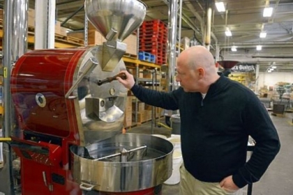 Bill Swoope Jr., owner of Coffee Tree Roasters, checks on the beans being roasted at the company's facility in West Mifflin.