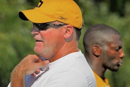 Kevin Colbert, General Manager of the Pittsburgh Steelers surveys a training camp practice in 2011 while safety Ryan Clark walks by behind him.