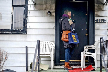 Marlee Gallagher of Wilkinsburg walks along Wallace Avenue going door to door to try and collect signatures on a petition aiming to allow liquor licenses to be distributed in Wilkinsburg.