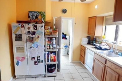 The kitchen features light oak cabinets, white appliances and white ceramic floors and neutral solid surface counter tops.