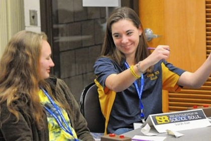 Norwin High School's Sarah Kerr, right, pumps her fists after answering correctly, while her teammate Alexis Boytim looks on during the Southwestern Pennsylvania Science Bowl at the South Campus of CCAC on Saturday.