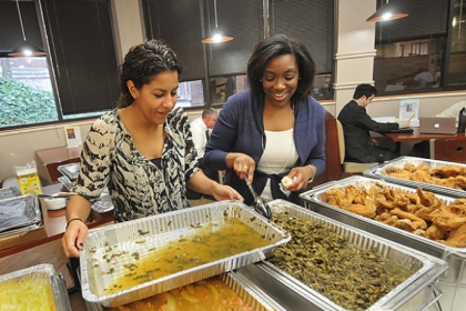 Simone Delerme, left, a third-year-law student and vice president of the Black Law Student Association works with Professor Tracey McCants Lewis to replace a pan of greens on the soul food sampler line at the Duquesne University law school.