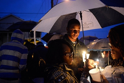 Friends of Brian "Lil Brucey" Wright Jr., 26, including Ricardo Grimsley (center) pay their respects during a vigil Tuesday evening at the corners of Enterprise Street and Tangent Way in Larimer.