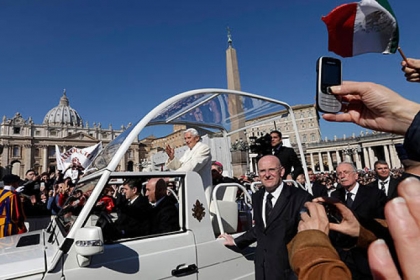 Pope Benedict XVI is driven through the crowd as he arrives to celebrate his last general audience in St. Peter's Square, at the Vatican.