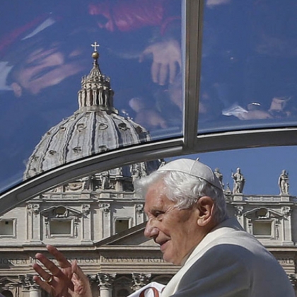 Faithful are reflected in the roof of Pope Benedict XVI's pope-mobile as he arrives to celebrate his last general audience in St. Peter's Square today.
