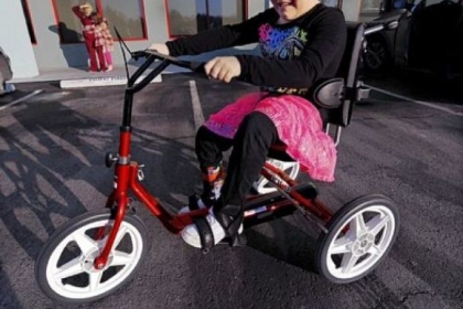 As Jennifer Shipe and daughter, Maddie, 8, look on, Maddie's twin sister, Abby Shipe, pedals her new adaptive bike provided by Variety the Children's Charity of Pittsburgh around the parking lot of Children's Hospital of Pittsburgh of UPMC's outpatient facility in Pine on Monday.
