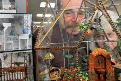 Caesar Palermo, left, and Terri Hirt created this miniature scene, which is for sale at Lynlott Miniatures Dollhouse Junction in Aspinwall. Mr. Palermo creates the glass cases, and Ms. Hirt decorates them.