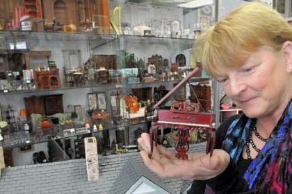 Debbie McManus, owner of Lynlott Miniatures Dollhouse Junction, examines a piano at the shop. The store is on Commercial Avenue in Aspinwall. Generally, if you can find it in your real house, you can buy it for your dollhouse.