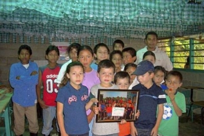 Jose Daniel, back row far left, with elementary school classmates holding a picture of Neil Armstrong Student Council in 2007, the first year the Student Council sold coffee to raise funds for scholarships in Honduras.