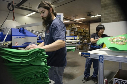 Joe Bonidie, left, and Aung N'yo pull Pittsburgh's official St. Patrick's Day Parade T-shirts off the presses Thursday at All Pro Embroidery and Screenprinting in Baldwin.