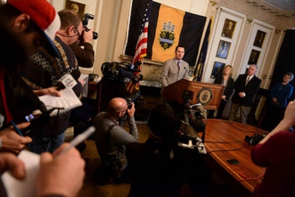 Reporters and photographers swarm Mayor Luke Ravenstahl during a press conference.