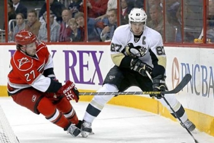 Sidney Crosby handles the puck behind the Hurricanes net.