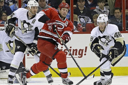 Carolina's Jordan Staal, center, chases the puck against Penguins' Brooks Orpik, left, and Joe Vitale during the first period of last night's 4-1 Carolina victory.