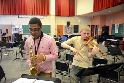 Terrell Williams, 17, on saxophone and John Brosovich, 17, on violin of the CAPA House Band rehearse. It will play during the home show.
