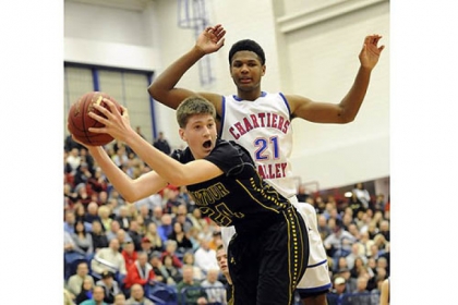 Montour's Dustin Sleva grabs a rebound against Chartiers Valley's Spencer Casson in the WPIAL class AAA championship Friday night at Palumbo Center.