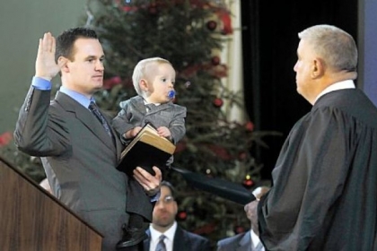 Luke Ravenstahl holds son, Cooper, on Jan. 4, 2010, as he takes the oath of office for Mayor of Pittsburgh, given by his father, District Judge Robert Ravenstahl Jr.