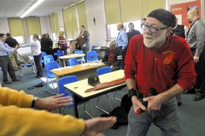 John Marucci, right, maintenance director for North Catholic High School, disarms religion teacher Greg Evans, who was holding a mock gun, during a training exercise.