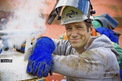 Mike Rowe next to venting gas on torch bottles at Cash's Scrap Metal in St. Louis during one of the episodes of "Dirty Jobs" on the Discovery Channel.
