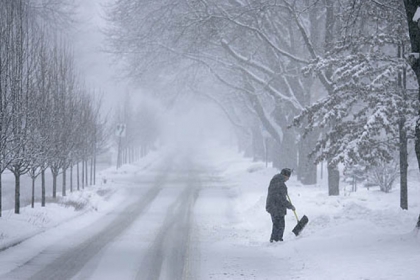 John Baer of Elgin, Ill., finishes shoveling half of his driveway Tuesday during a snow storm in the suburbs of Chicago, Ill.