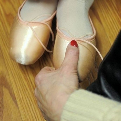 A Pittsburgh Ballet School student is checked to see if her first pair of pointe shoes fit correctly.