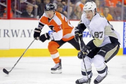 Penguins center Sidney Crosby, right, brings the puck up the ice as he is trailed by Ruslan Fedotenko of the Flyers.