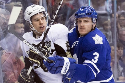 The Toronto Maple Leafs' Dion Phaneuf battles against the boards in the first period with the Penguins' Sidney Crosby.
