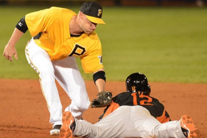 Baltimore's Alexi Casilla slides under the tag of  Pirates shortstop Clint Barmes.