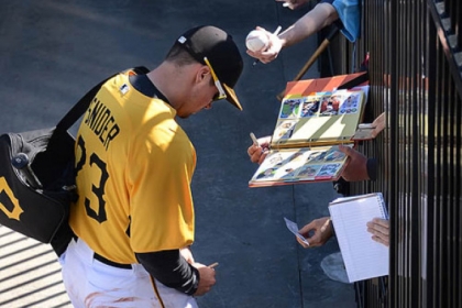 Fans reach through the fence to get autographs from Travis Snider Friday in Bradenton, Fla.