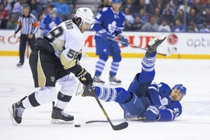 Toronto's James van Riemsdyk, right, tries to play the puck from his back against the Penguins' James Neal in the second period Saturday night in Toronto.