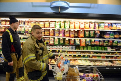 Lt. John Gardell, center, and firefighter Dan Reiser, return to Giant Eagle to find their cart exactly where they left it on Friday, Jan. 18, 2013.