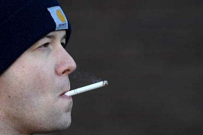 Firefighter Dan Reiser smokes a cigarette while engine 17 wraps up a call about sparking power lines on Friday, Jan. 18, 2013.