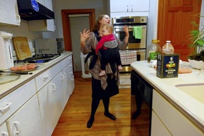 Like other moms who work outside of the home, Stefanie Small of Squirrel Hill says the most stressful part of her day is when she returns home from work as a geriatric social worker to care for her three children. She uses a carrier to hold 11-month-old Aria as she makes dinner.