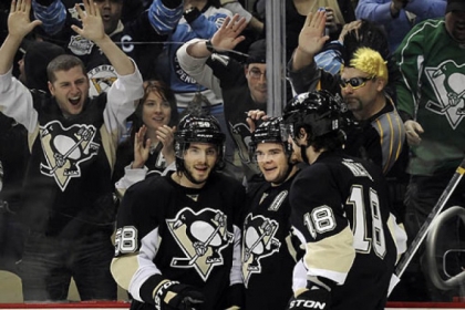 Chris Kunitz, center, is congratulated by Kris Letang, left, and James Neal after scoring his second goal in the first period  against the New York Islanders.