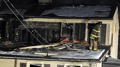 A Pittsburgh firefighter takes part in the investigation of a two-alarm blaze this morning at 1920 Plateau St. in Carrick.