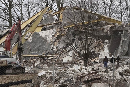 Workers watch the demolition of the Gettysburg Cyclorama building on Monday in Gettysburg, Pa.