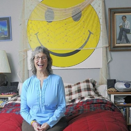 Julie Ann Sullivan has lots of visual reminders about good-hearted living, including a large smiley face above her bed. She leads laughter workshops throughout the region, teaching people to keep a positive outlook.