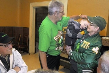 Denny Donnelly of Heidelberg, left, greets Colleen McKelvey and her grandson, Patrick, 2, both of Carnegie at the Lenten fish fry held by Division 32 of the Ancient Order of Hibernians at the Ukrainian American Club in Carnegie.