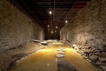 From the Mattress Factory exhibition "Feminist And ...": Betsy Damon's "Water Rules Life Pittsburgh: Seeking Lost Rivers, Living Waters of Larimer" (2012), including sand, water, rocks, burlap, concrete, topographical map, audio, video.