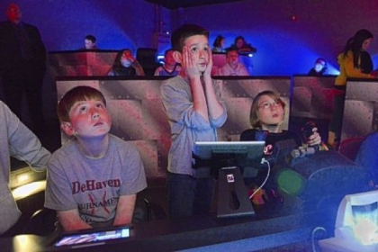 Shaler Area Elementary School fifth-graders Nick Rispoli, 11, Michael Bly, 11, and Bella James, 10, take a trip Thursday to the site of the sinking of the Lusitania using the Dream Flight Adventures simulator.