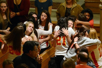 Members of the Seton Hill University women's lacrosse team, wearing their team jerseys, embrace on Sunday evening during a memorial Mass for Kristina Quigley, their pregnant coach, and Anthony Guaetta, the driver of their bus, who died Saturday in a crash on the Pennsylvania Turnpike.