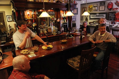 Mike Price tends bar for a house party at the South Side home of his parents, Jim and Monica Price, far left and right, and their friends Ken Mary and his wife, Pam. Mike built the bar.