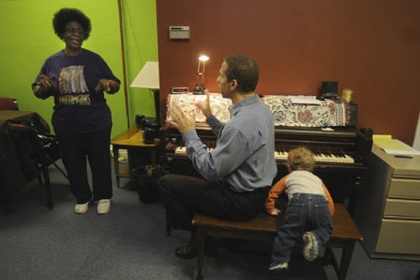 Dora Lee Pryor, left, takes vocal lessons at The Corner in West Oakland from Eugene Perry, who is accompanied by his 15-month-old son, Elijah.