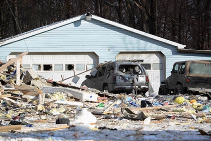 A damaged garage and vehicles are adjacent to a house explosion  in Clearfield Township, Cambria County today.