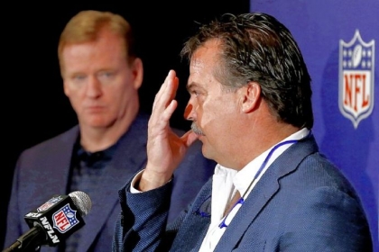 With NFL commissioner Roger Goodell looking on, St. Louis Rams head coach and co-chairman of the NFL competition committee Jeff Fisher gestures while explaining a new rule passed by the owners that bars ballcarriers from using the crown of their helmets to make forcible contact with a defender in the open field.