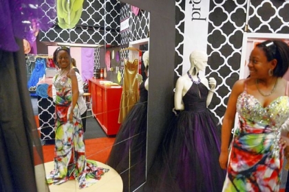 Seausa Williams, 18, of McKeesport tries on prom dresses inside the Project Prom Shop at Century III Mall in West Mifflin on March 11.  Project Prom, now in its 10th year, gives away dresses to girls with families that may not be able to afford a gown.