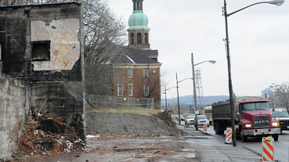 The demolished Allegheny Auto Body leaves St. Nicholas Church as the last structure standing along East Ohio St. on Pittsburgh's North Side. Demolition preparations are ongoing inside the church. 