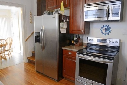 The kitchen has cherry wood cabinets and laminate counter tops. To the left is the breakfast nook.